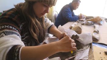 Alex and Jim carefully clean delicate bone artifacts.