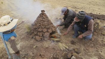 Every Wednesday, we break for a special lunch called huatia. First David, Rohelio, and Javier build a small oven with dirt clods.