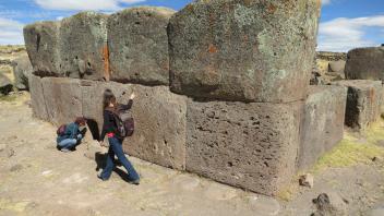 Lauren and Erika inspecting an Inca chulpa (burial tomb) during a visit to Sillustani.