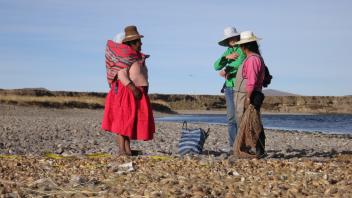 Lauren and Virginia talk with a Totorani woman about producing tunta - freeze dried potatoes seen in the foreground.