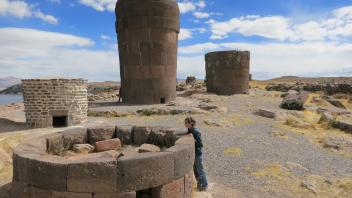 Lauren inspects an Inca chulpa (burial tomb) during a visit to Sillustani.