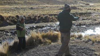 Mateo teaches Nathaniel to use an honda--Andean sling--at the Ccoypani field site.