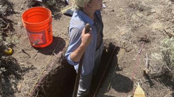 Shelby is at work in her unit with a shovel.