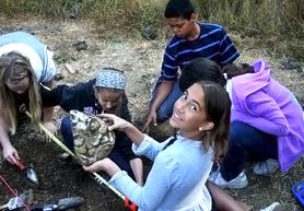 grade school children exploring an artifact